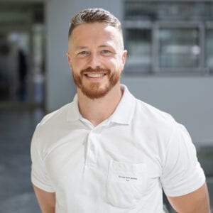 Lächelnder Arzt in einem weißen Polohemd