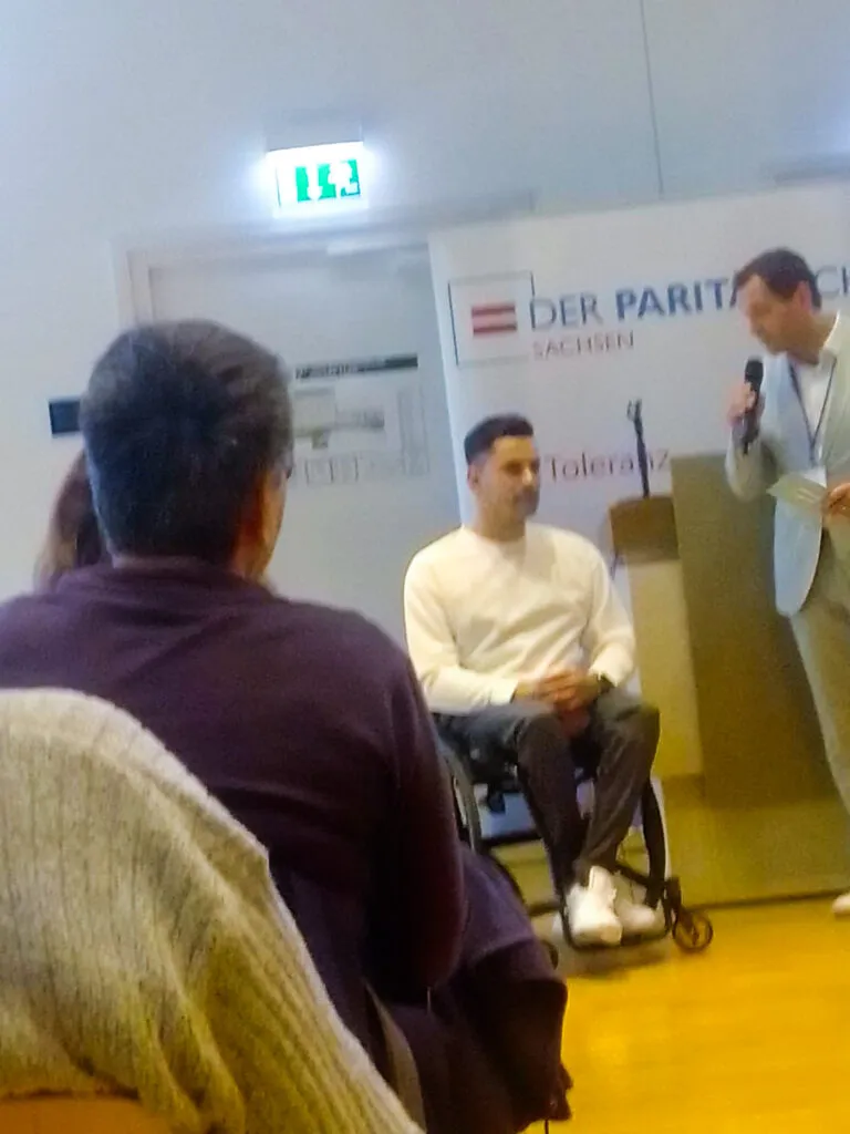Veranstaltung mit Rede und Teilnehmer im Rollstuhl
